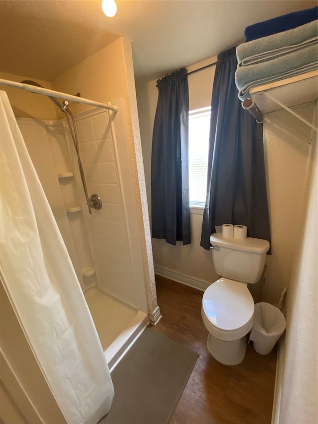 bathroom featuring hardwood / wood-style floors, a shower with shower curtain, and toilet