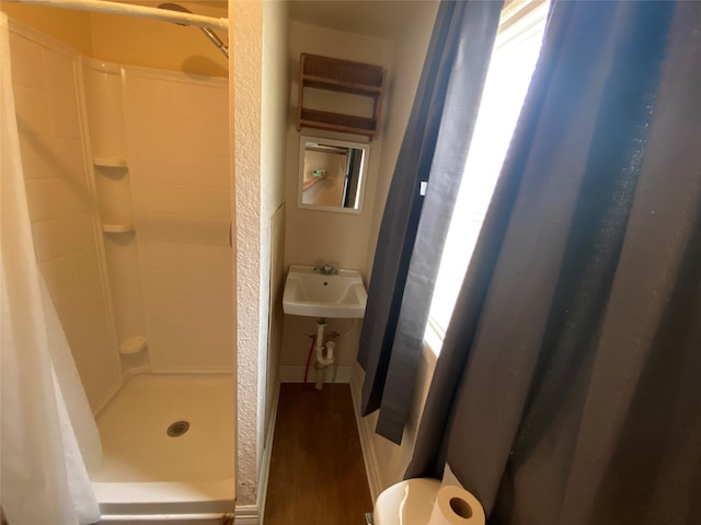 bathroom featuring toilet, wood-type flooring, sink, and a shower with shower curtain