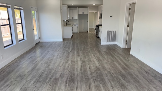 unfurnished living room featuring hardwood / wood-style floors and sink