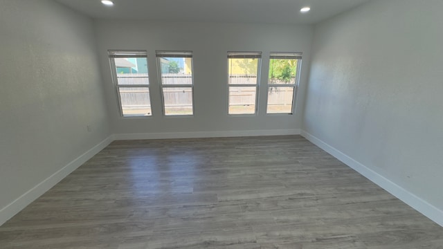 unfurnished room with hardwood / wood-style flooring and a wealth of natural light