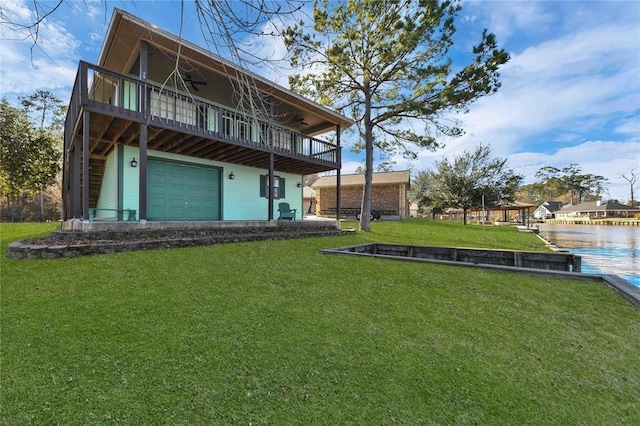 back of property with a balcony, a garage, and a yard