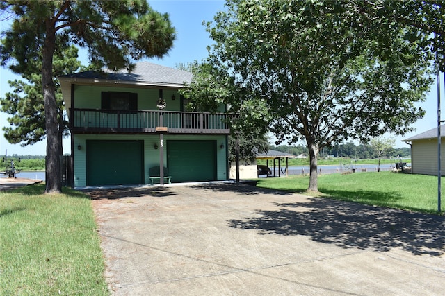 view of front property with a balcony, a front yard, and a garage