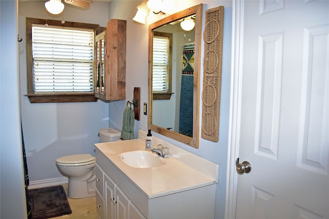 bathroom with a healthy amount of sunlight, toilet, and vanity