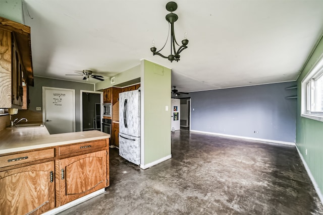 kitchen featuring stainless steel microwave, pendant lighting, ceiling fan, sink, and white refrigerator