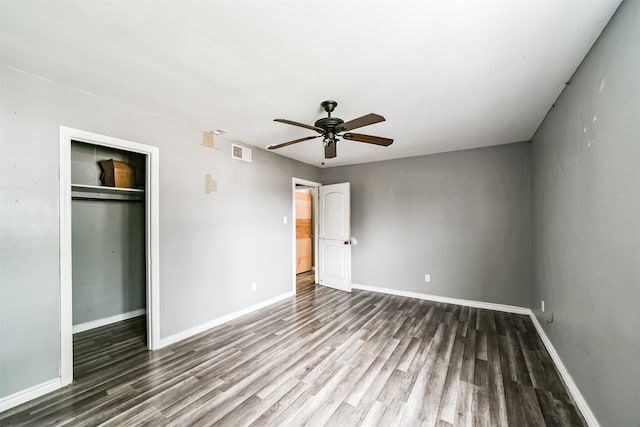 unfurnished bedroom with dark hardwood / wood-style flooring, ceiling fan, and a closet