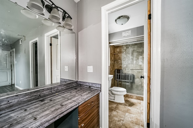 bathroom with vanity, toilet, tile floors, and an enclosed shower