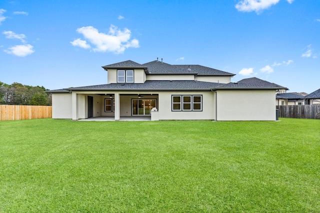 back of property with a lawn, ceiling fan, and a patio area