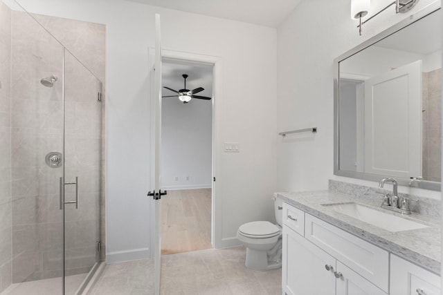 bathroom featuring vanity, ceiling fan, a shower with shower door, and toilet