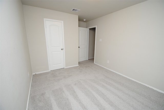 unfurnished bedroom featuring a closet and light colored carpet