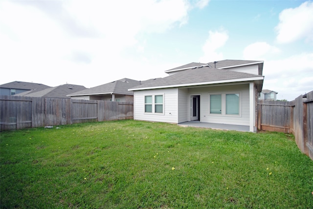 back of house featuring a patio area and a lawn