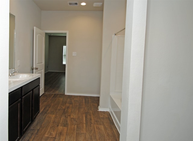 bathroom featuring hardwood / wood-style floors, large vanity, and bathing tub / shower combination