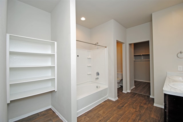 full bathroom with toilet, double vanity, bathtub / shower combination, and hardwood / wood-style flooring