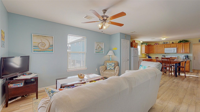 living room featuring light hardwood / wood-style floors and ceiling fan