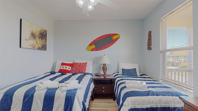 bedroom with light hardwood / wood-style flooring, ceiling fan, and multiple windows