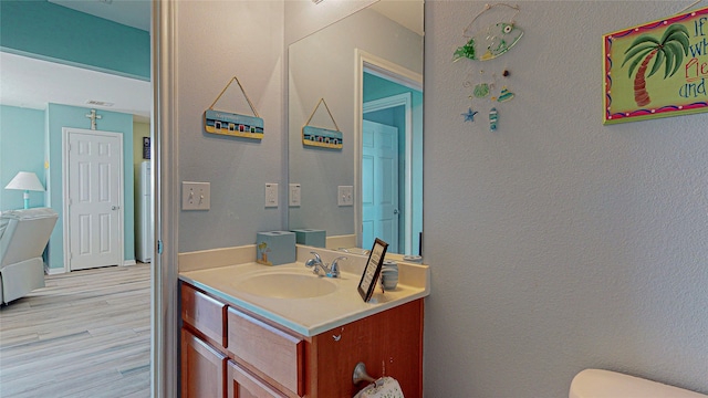 bathroom featuring hardwood / wood-style flooring, toilet, and vanity