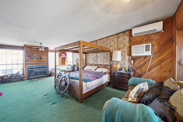 bedroom with wood walls, dark carpet, a wall mounted AC, and a fireplace