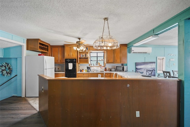 kitchen with double oven, a textured ceiling, ceiling fan with notable chandelier, hardwood / wood-style floors, and hanging light fixtures