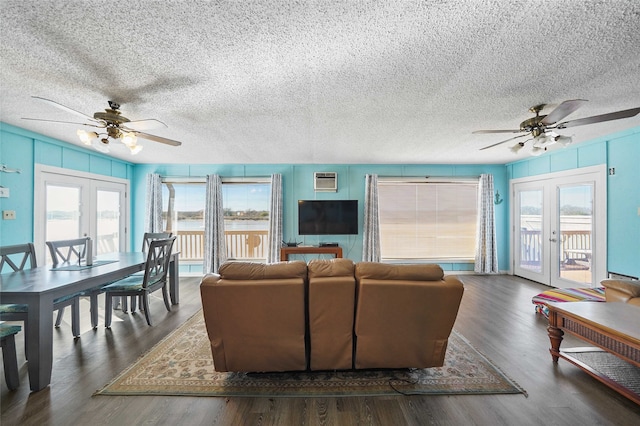 living room with plenty of natural light, french doors, ceiling fan, and dark wood-type flooring