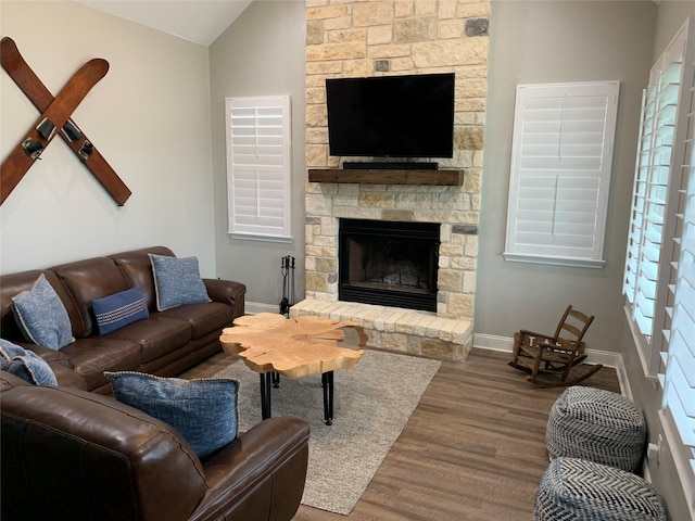 living room featuring lofted ceiling, hardwood / wood-style flooring, and a fireplace