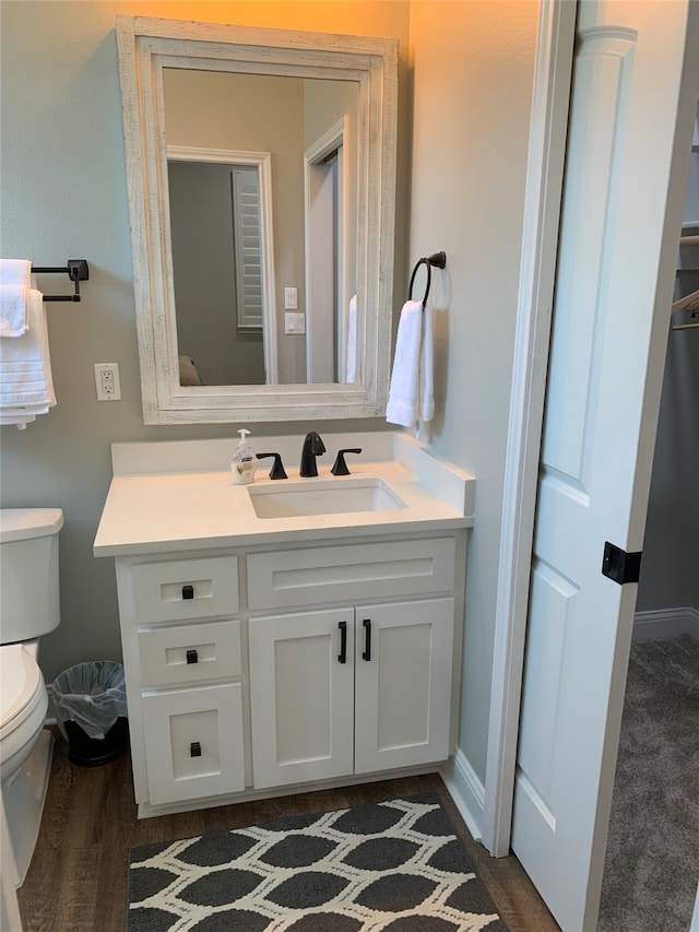 bathroom featuring toilet, vanity, and hardwood / wood-style flooring