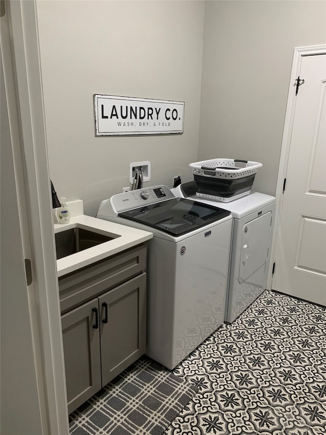 laundry room with washer hookup, cabinets, washing machine and clothes dryer, and dark tile flooring