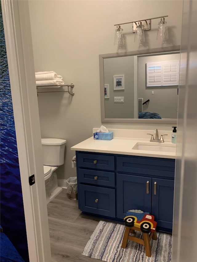 bathroom with hardwood / wood-style floors, toilet, and large vanity