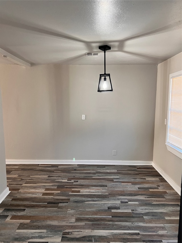 unfurnished room featuring ceiling fan, dark wood-type flooring, and a textured ceiling