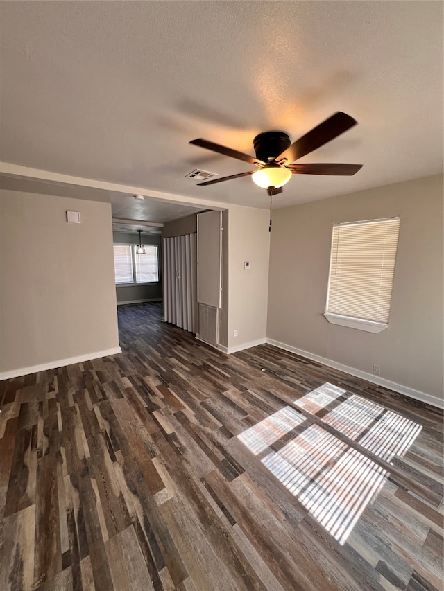 empty room featuring dark hardwood / wood-style floors, a textured ceiling, and ceiling fan