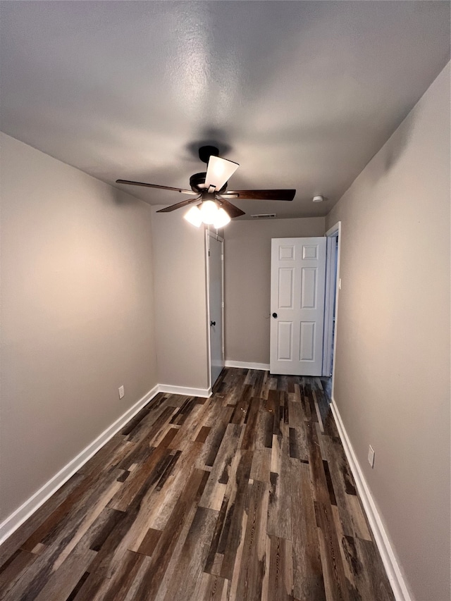 spare room with dark wood-type flooring and ceiling fan