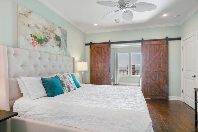 bedroom with dark wood-style floors, a barn door, ornamental molding, and baseboards