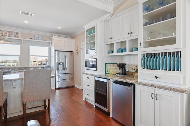 kitchen with beverage cooler, stainless steel appliances, visible vents, white cabinets, and glass insert cabinets