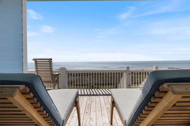 wooden deck featuring a beach view and a water view