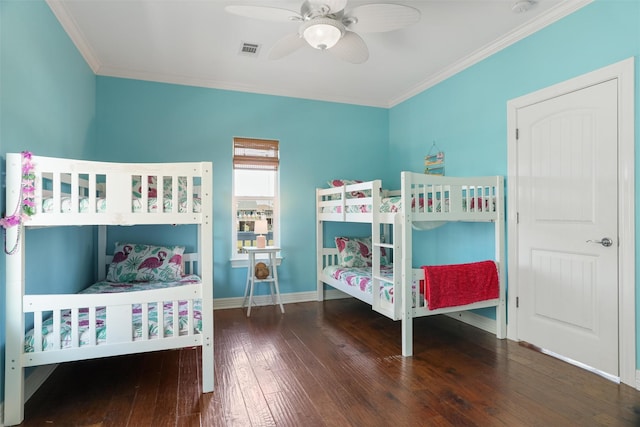 bedroom featuring wood finished floors, a ceiling fan, visible vents, baseboards, and ornamental molding