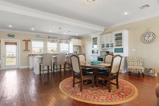 dining room with a healthy amount of sunlight, visible vents, and dark wood-type flooring