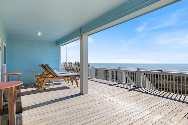 wooden deck featuring a water view and a view of the beach