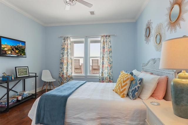 bedroom with dark wood-style flooring, crown molding, visible vents, a ceiling fan, and baseboards