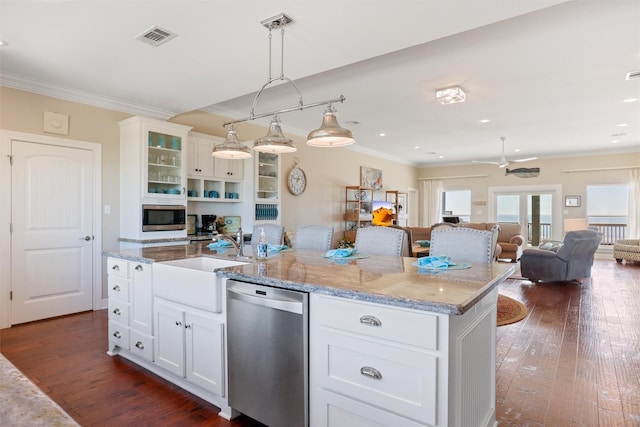 kitchen with visible vents, white cabinetry, hanging light fixtures, appliances with stainless steel finishes, and a center island with sink