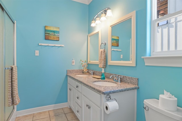 bathroom with baseboards, a sink, toilet, and tile patterned floors