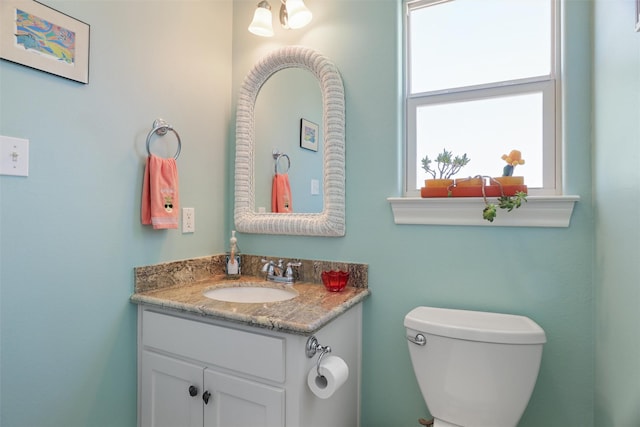 half bathroom with toilet and vanity