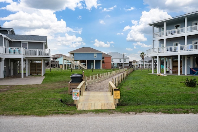 view of community with a patio area, a residential view, a vegetable garden, and a lawn