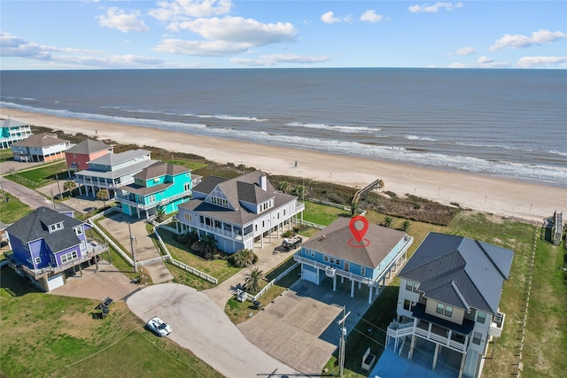 drone / aerial view featuring a water view, a residential view, and a view of the beach