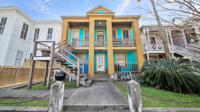 townhome / multi-family property featuring stairway, brick siding, and a porch