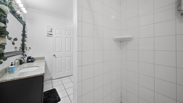 full bath featuring tile patterned floors, tiled shower, ornamental molding, and vanity