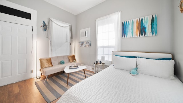 bedroom featuring wood finished floors and ornamental molding