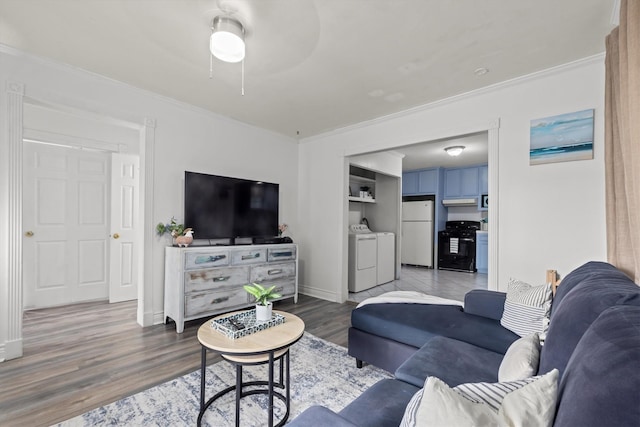 living room with baseboards, wood finished floors, independent washer and dryer, and ornamental molding