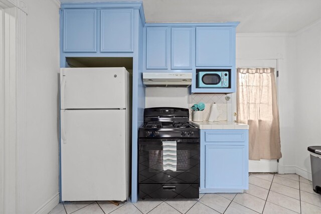 kitchen with black range with gas stovetop, blue cabinetry, tile counters, under cabinet range hood, and freestanding refrigerator