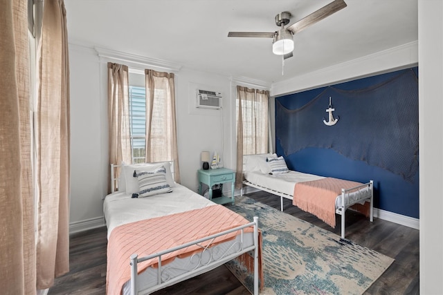 bedroom featuring a wall mounted air conditioner, baseboards, wood finished floors, and a ceiling fan