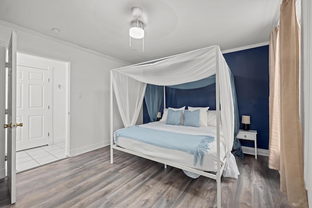 bedroom featuring crown molding, wood finished floors, and baseboards