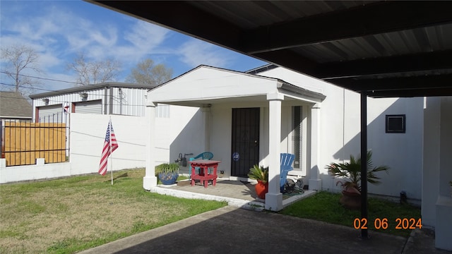 property entrance featuring a patio and a yard