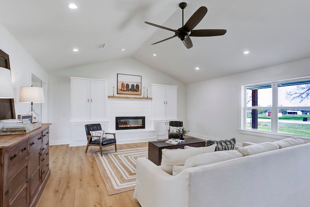 living room with ceiling fan, lofted ceiling, and light hardwood / wood-style floors